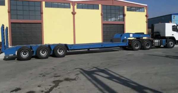 3-axle, 12-inch tire, lowbed trailer with storage compartment.